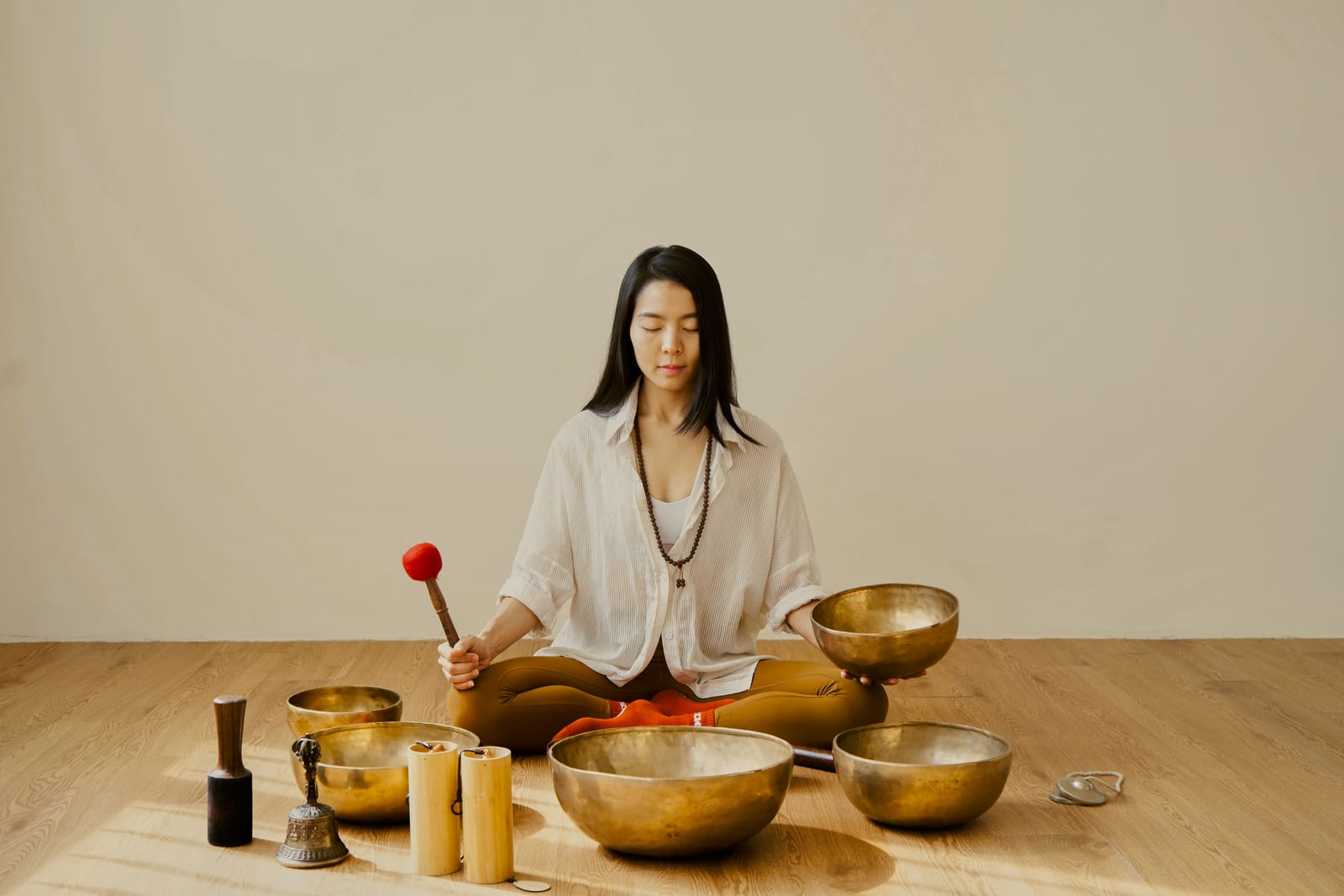 An instructor playing singing bowls during a sound bath at Hae Studio