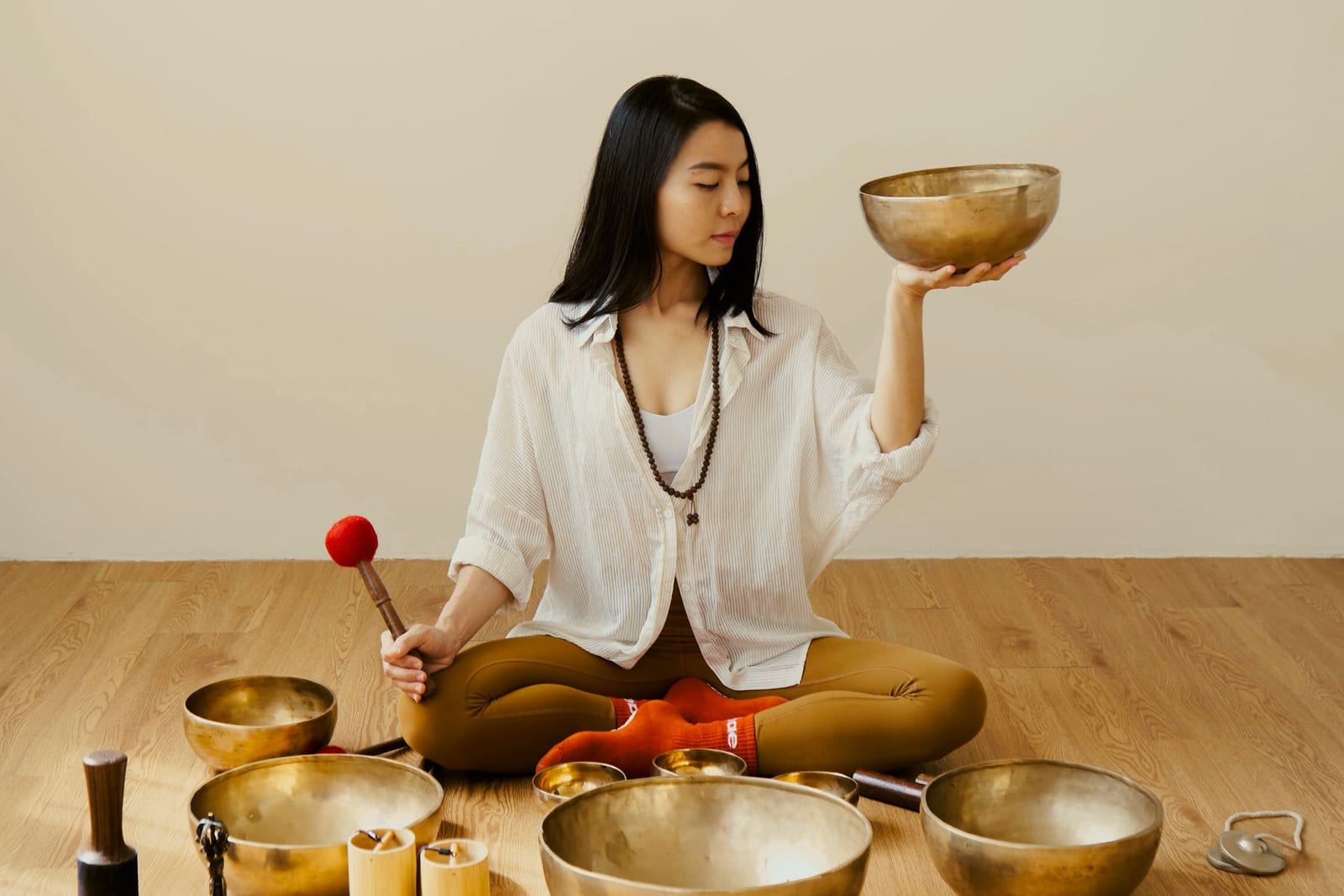 An instructor with a singing bowl before a special class at Hae Studio